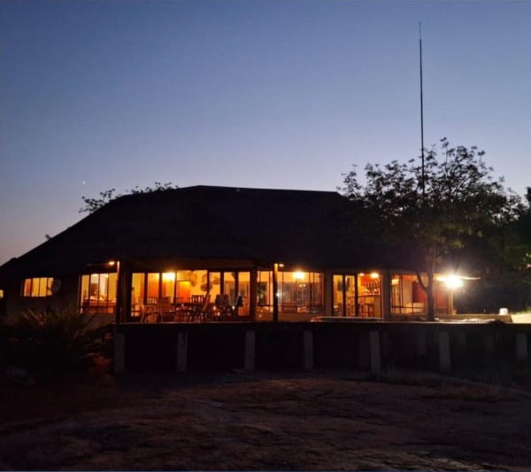 The lodge at dusk with warm light from the dining room