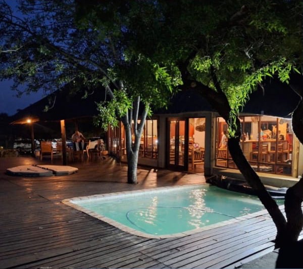 The pool and deck outside the lodge at night